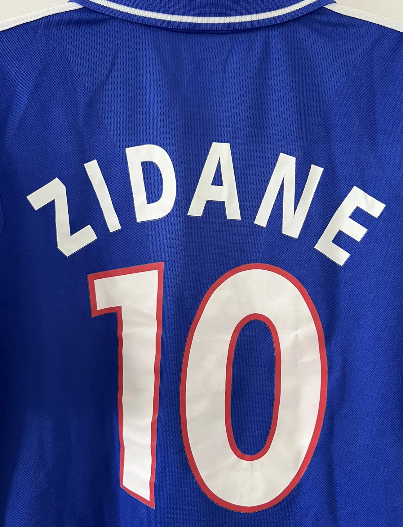 Maillot de foot vintage domicile de l'équipe de france 2000. Le maillot est de couleur bleu blanc et rouge. On peut retrouver l'équipementier adidas. Le maillot est floqué du numéro 10 Zinedine Zidane. Il s'agit d'un maillot authentique comportant les numéros 647194.