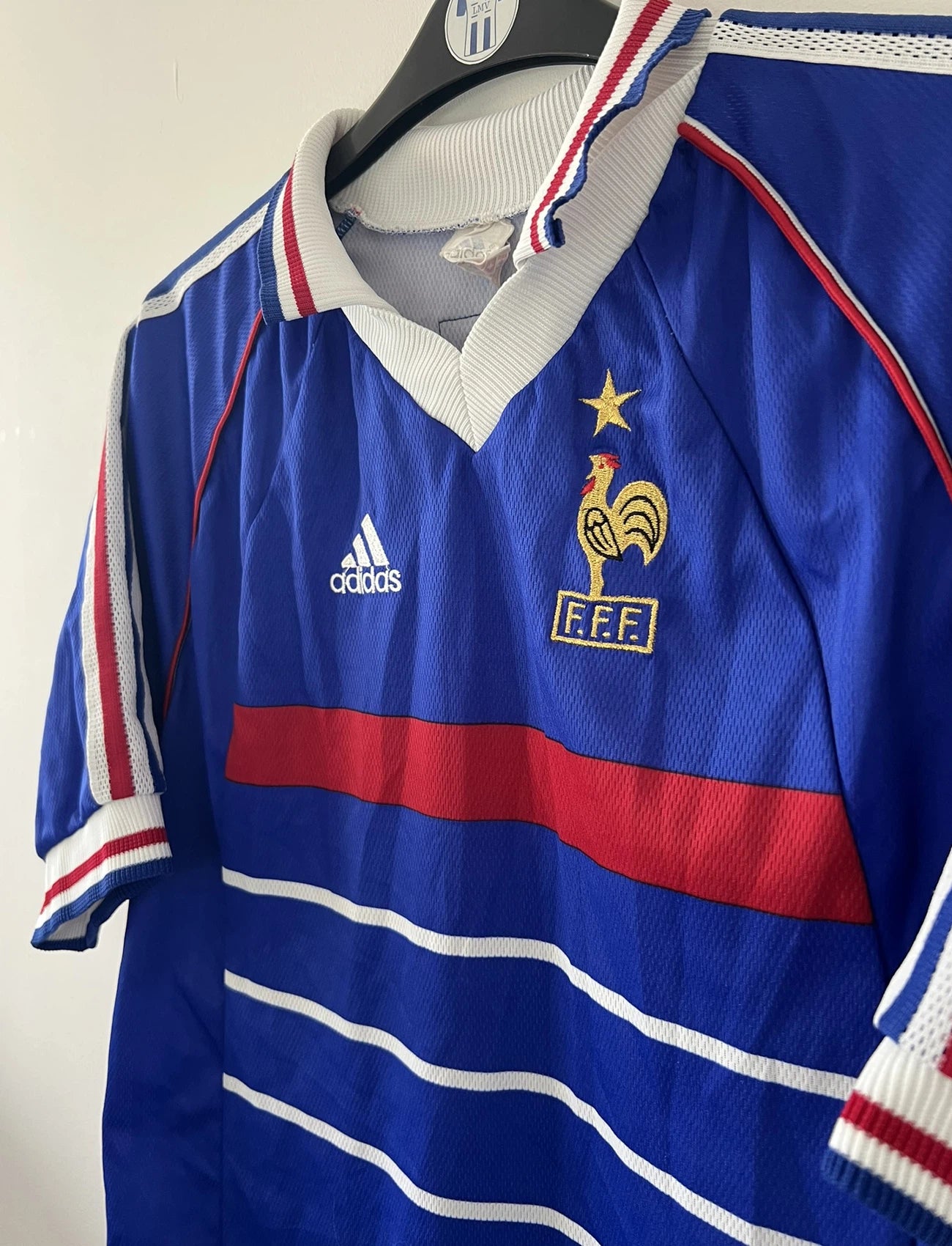 Maillot de foot vintage domicile bleu de l'équipe de france 1998. On peut retrouver l'équipementier Adidas. Le maillot est floqué du numéro 10 Zinedine Zidane. Il s'agit d'un maillot authentique d'époque.