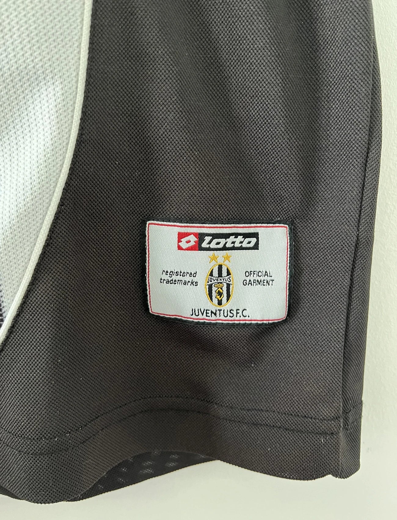 Maillot de foot vintage domicile noir et blanc de la juventus de turin de la saison 2002/2003. On peut retrouver l'équipementier lotto et le sponsor fastweb. Il s'agit d'un maillot authentique d'époque.