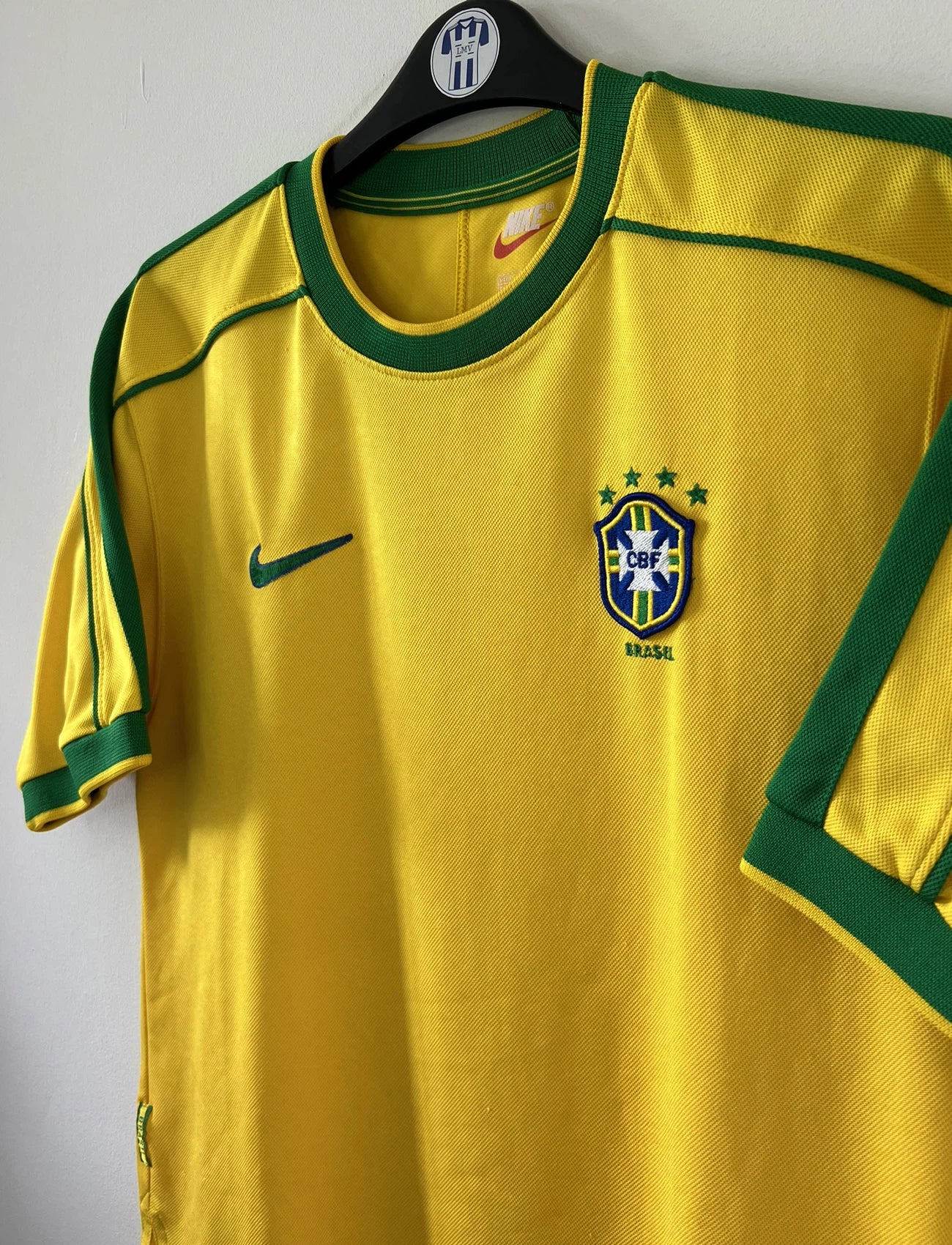 Maillot de foot vintage domicile du bresil 1998. Le maillot est de couleur jaune et vert. On peut retrouver l'équipementier nike. Ils 'agit d'un maillot authentique d'époque.