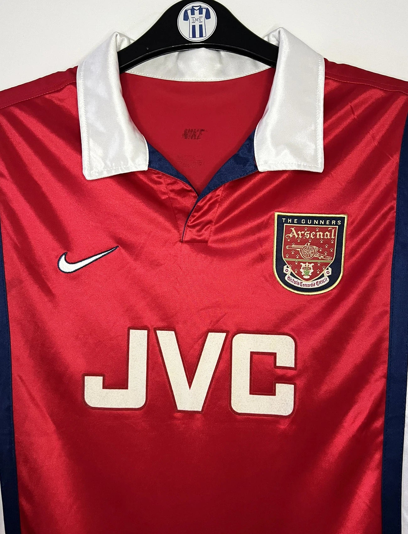 Maillot de foot vintage domicile rouge et blanc version manche longue d'Arsenal de la saison 1998/1999. On peut retrouver l'équipementier Nike et le sponsor JVC. Il s'agit d'un maillot authentique d'époque.