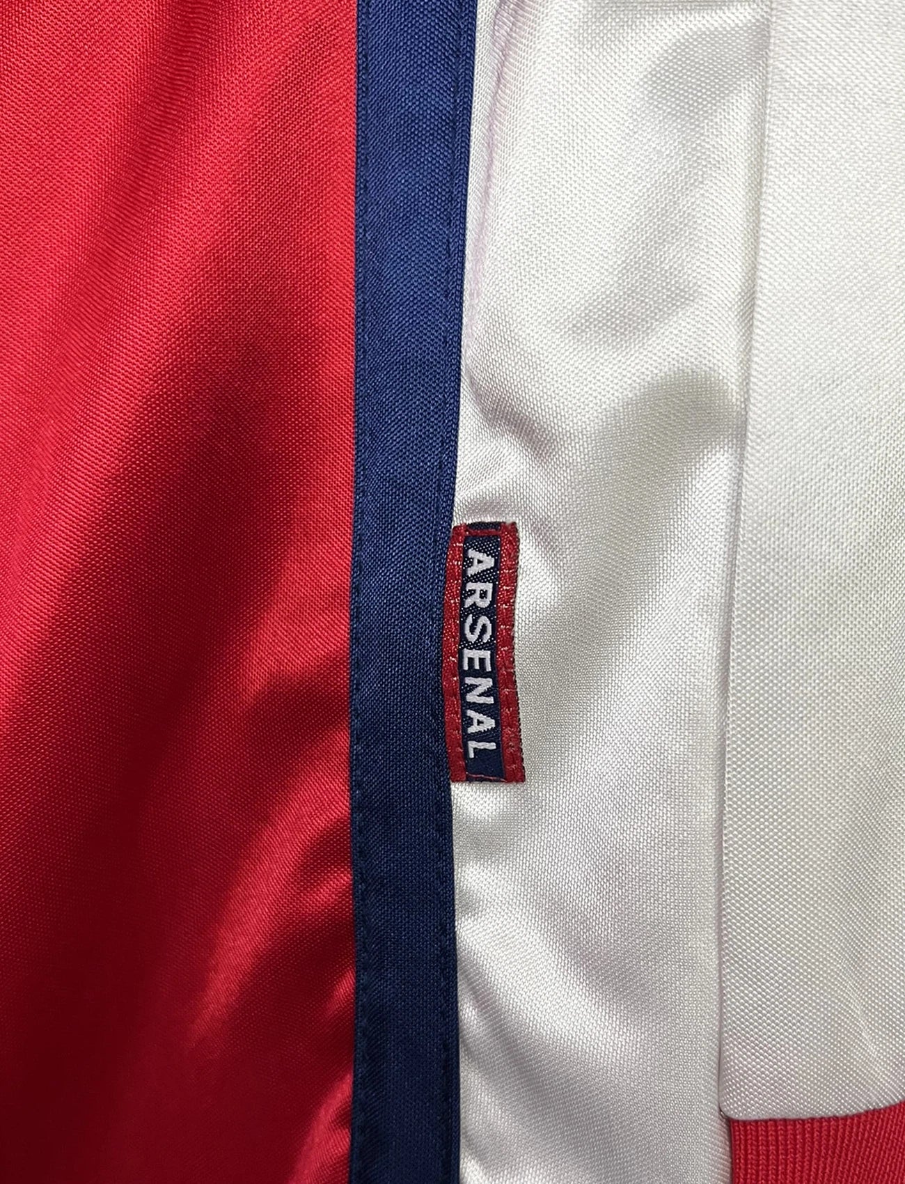 Maillot de foot vintage domicile rouge et blanc version manche longue d'Arsenal de la saison 1998/1999. On peut retrouver l'équipementier Nike et le sponsor JVC. Il s'agit d'un maillot authentique d'époque.