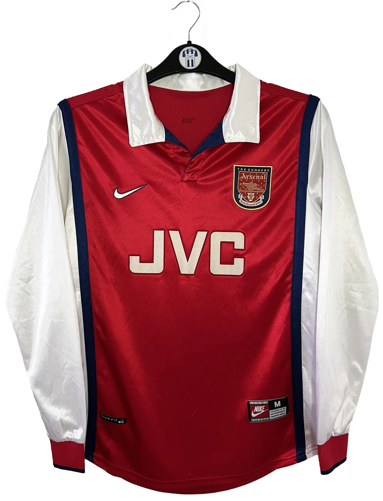 Maillot de foot vintage domicile rouge et blanc version manche longue d'Arsenal de la saison 1998/1999. On peut retrouver l'équipementier Nike et le sponsor JVC. Il s'agit d'un maillot authentique d'époque.