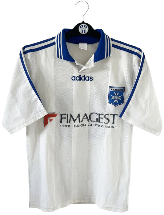 Maillot de foot vintage domicile blanc et bleu de l'AJ Auxerre de la saison 1997/1998. On peut retrouver l'équipementier adidas et le sponsor fimagest. Il s'agit d'un maillot authentique d'époque.