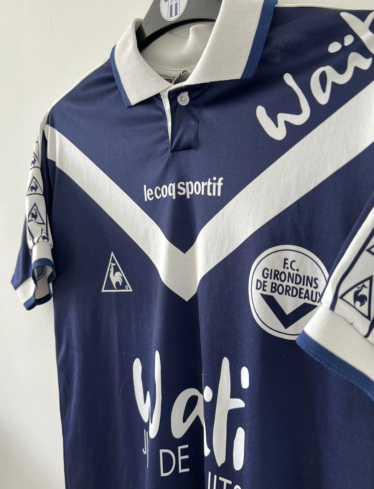 Maillot de foot vintage domicile des girondins de bordeaux de la saison 1996/1997. Le maillot est de couleur bleu et blanc. On peut retrouver l'équipementier le coq sportif et le sponsor waiti. Le maillot est floqué du numéro 27 Jean Pierre Papin. Il s'agit d'un maillot authentique d'époque