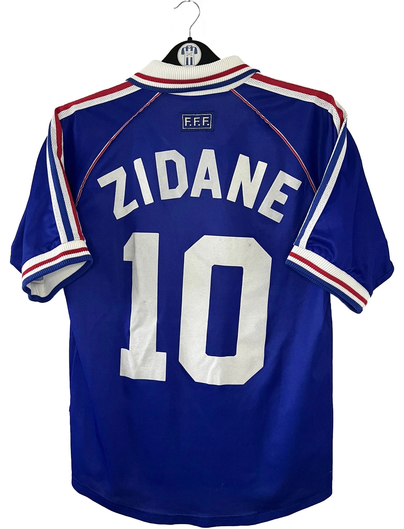 Maillot de foot vintage domicile bleu de l'Equipe de France 1998. On peut retrouver l'équipementier Adidas. Le maillot est floqué Zinedine Zidane. Il s'agit d'un maillot authentique d'époque.