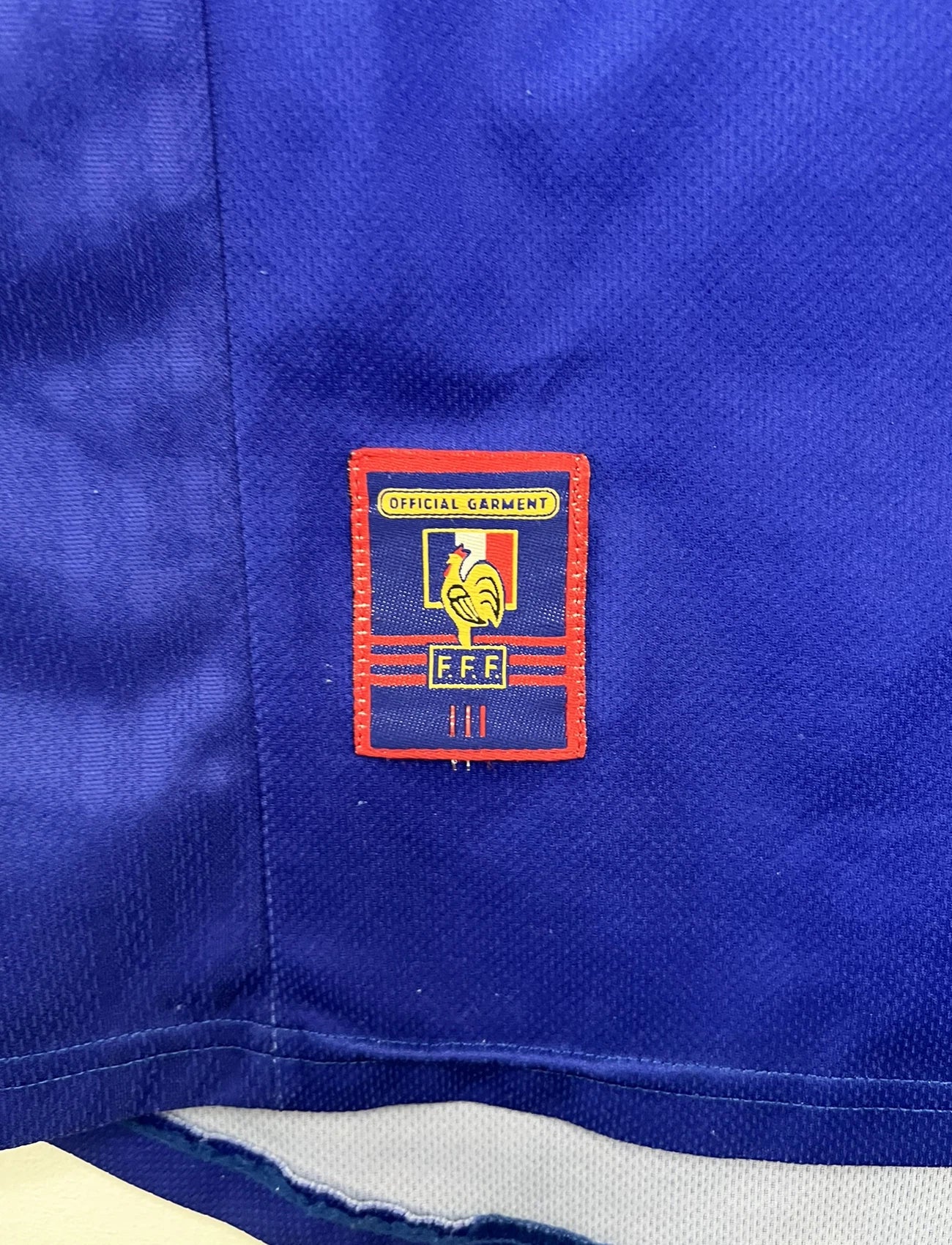 Maillot de foot vintage domicile bleu de l'Equipe de France 1998. On peut retrouver l'équipementier Adidas. Le maillot est floqué Zinedine Zidane. Il s'agit d'un maillot authentique d'époque.