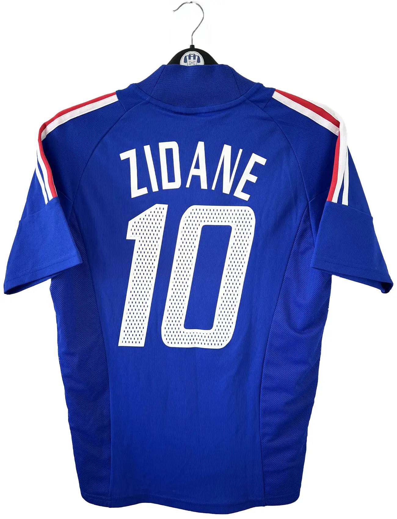 Maillot de foot vintage domicile de l'équipe de france 2002. Le maillot est de couleur bleu blanc et rouge. On peut retrouver l'équipementier adidas. Le maillot est floqué du numéro 10 Zinedine Zidane. Il s'agit d'un maillot authentique d'époque comportant les numéros 139531.