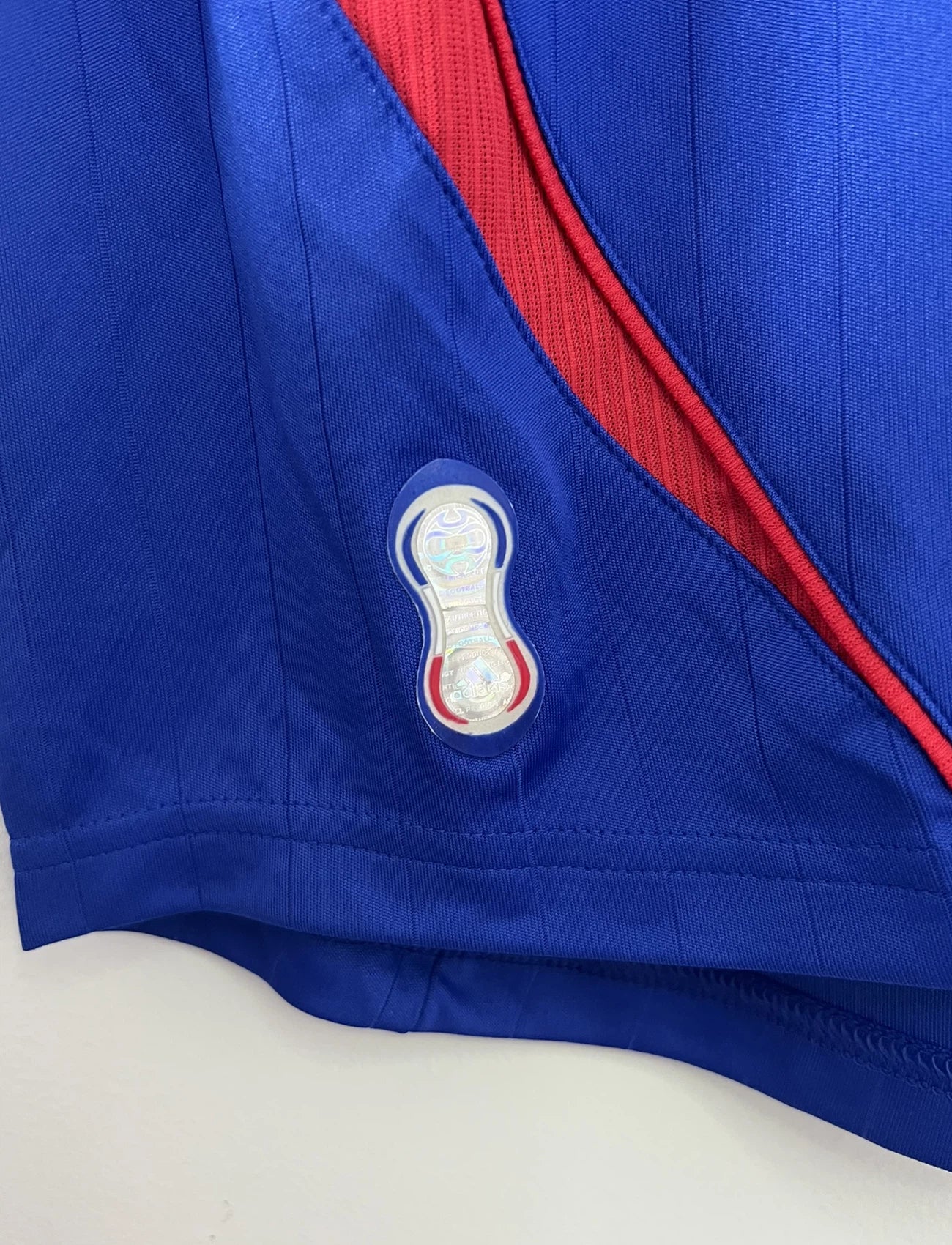 Maillot de foot vintage domicile bleu de l'équipe de france 2006. On peut retrouver l'équipementier adidas. Le maillot est floqué du numéro 10 Zinedine Zidane. Il s'agit d'un maillot authentique comportant l'étiquette 740126.