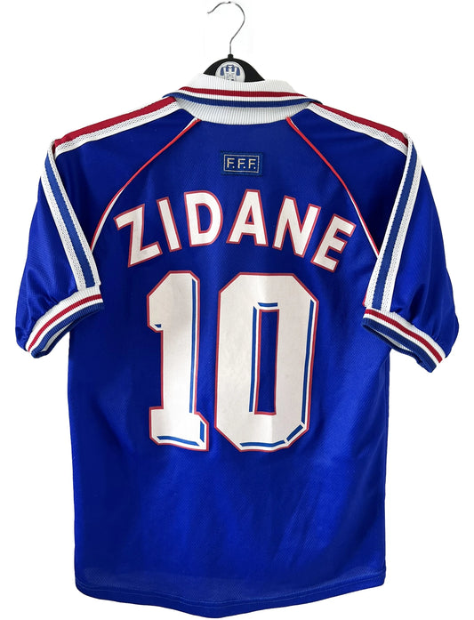 Maillot de foot vintage domicile bleu blanc et rouge de l'équipe de france lors de la coupe du monde 1998. On peut retrouver l'équipementier adidas. Le maillot est floqué du numéro 10 zinedine zidane. Il s'agit d'un maillot authentique d'époque.