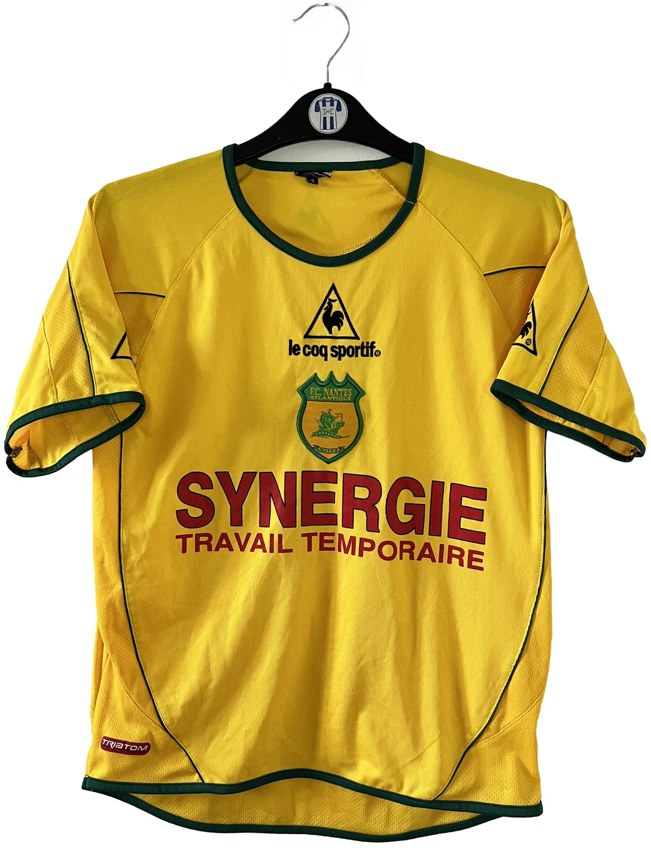 Maillot de foot vintage domicile jaune du FC Nantes de la saison 2003-2004. On peut retrouver l'équipementier Le Coq Sportif et le sponsor Synergie. Il s'agit d'un maillot authentique d'époque.