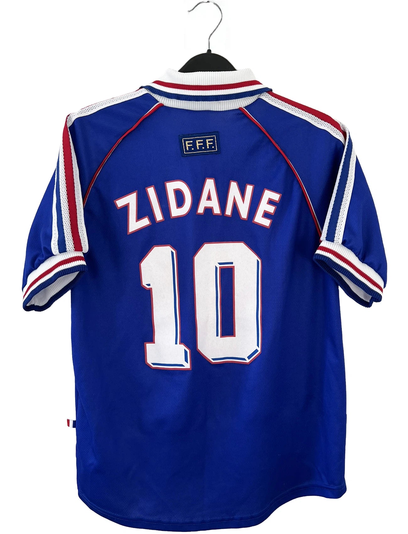 Maillot de foot vintage domicile de l'équipe de france 1998 bleu. On peut retrouver l'équipementier adidas. Le maillot est floqué du numéro 10 Zinedine Zidane. Il s'agit d'un maillot authentique d'époque.