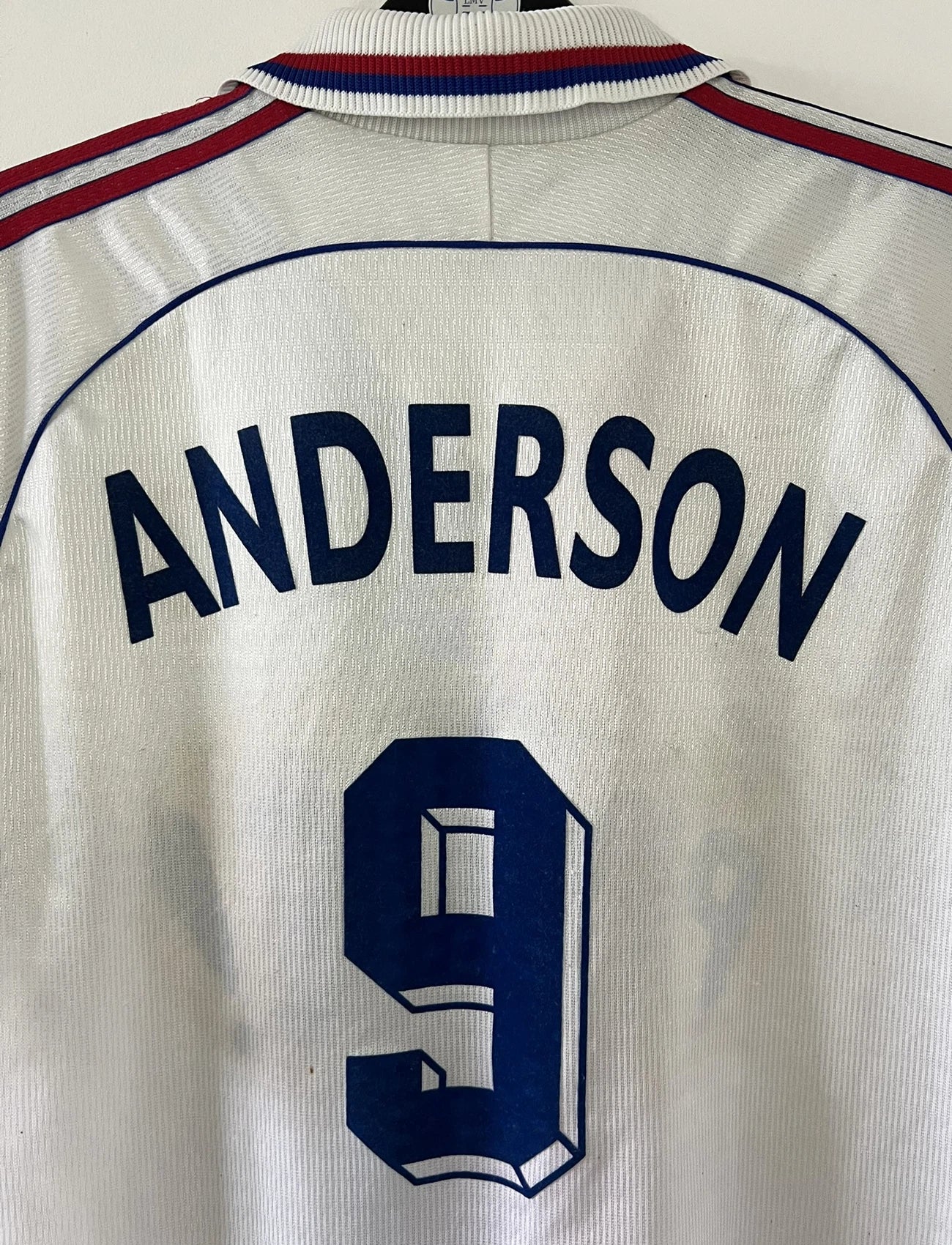 Maillot de foot vintage domicile blanc de l'OL de la saison 1999/2000. On peut retrouver l'équipementier adidas et le sponsor pathé. Le maillot est floqué du numéro 9 Sonny Anderson. Il s'agit d'un maillot authentique d'époque.