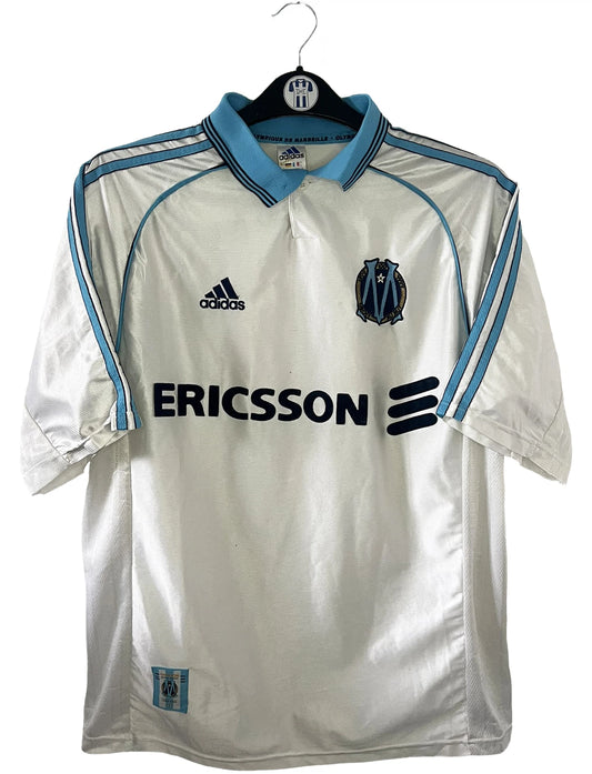 Maillot de foot vintage domicile de l'OM blanc de la saison 1998/1999. On peut retrouver l'équipementier adidas et le sponsor ericsson. Il s'agit d'un maillot authentique d'époque.