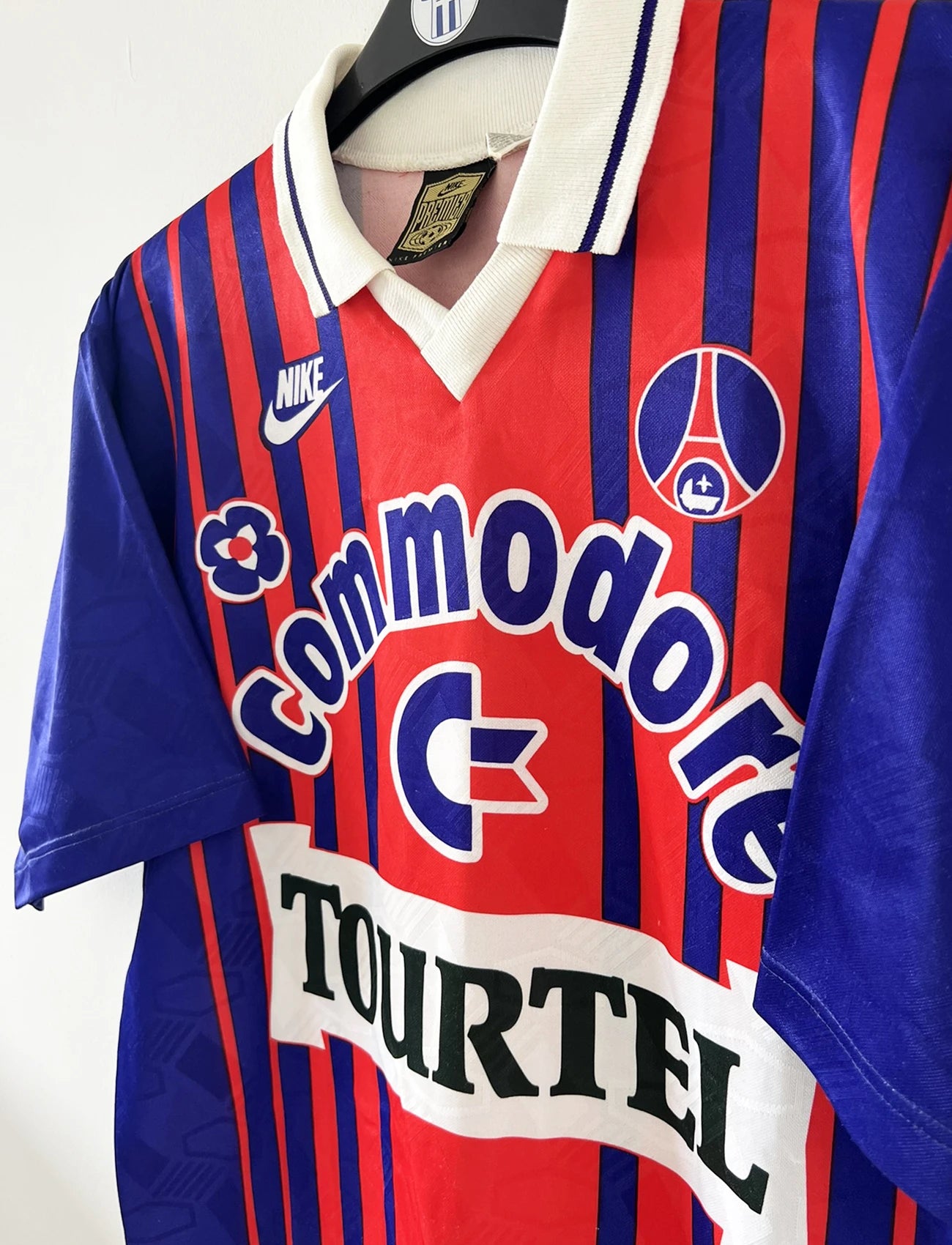 Maillot vintage domicile rouge et bleu du PSG de la saison 1993/1994. On peut retrouver l'équipementier nike, le sponsor commodore et le sponsor tourtel