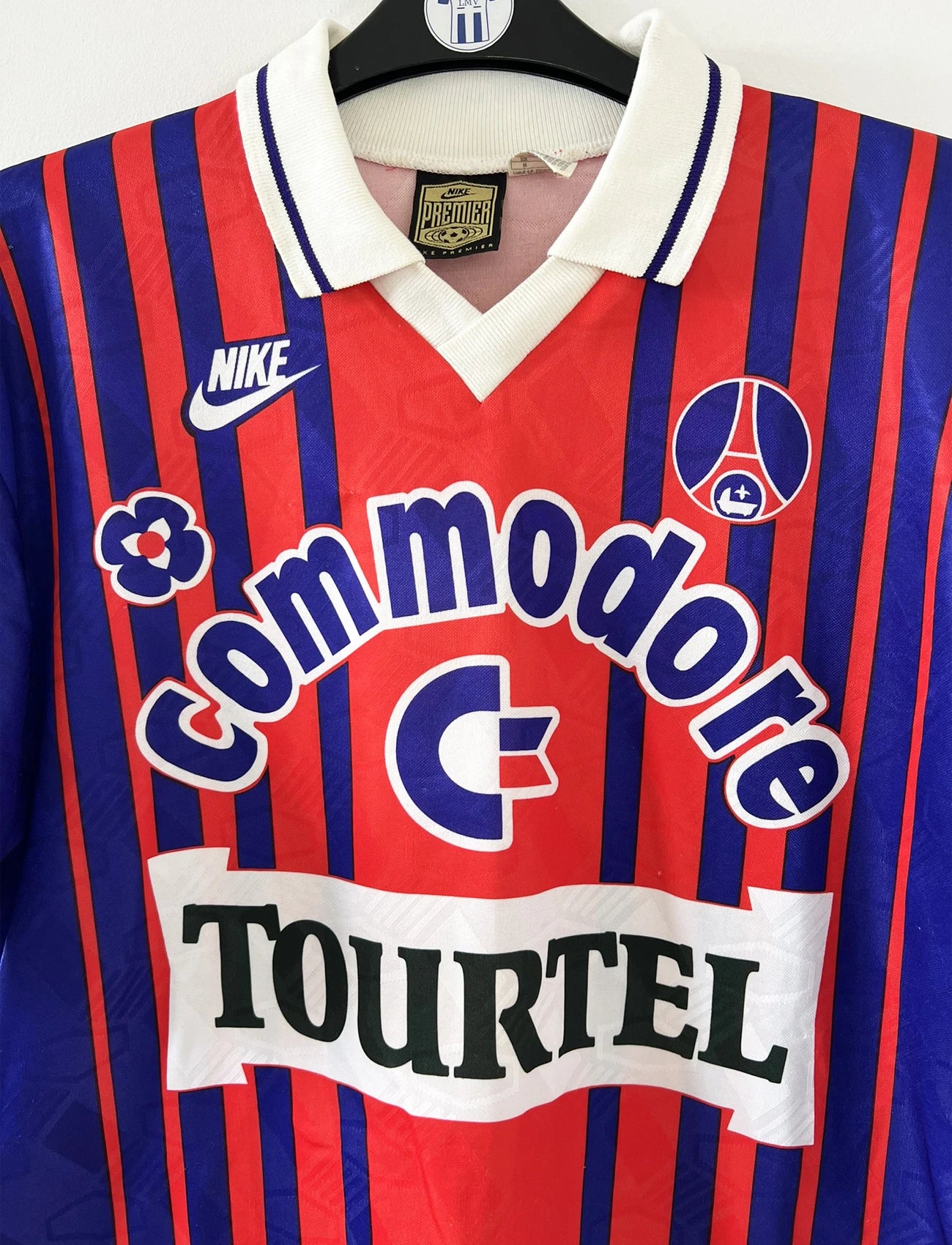 Maillot vintage domicile rouge et bleu du PSG de la saison 1993/1994. On peut retrouver l'équipementier nike, le sponsor commodore et le sponsor tourtel