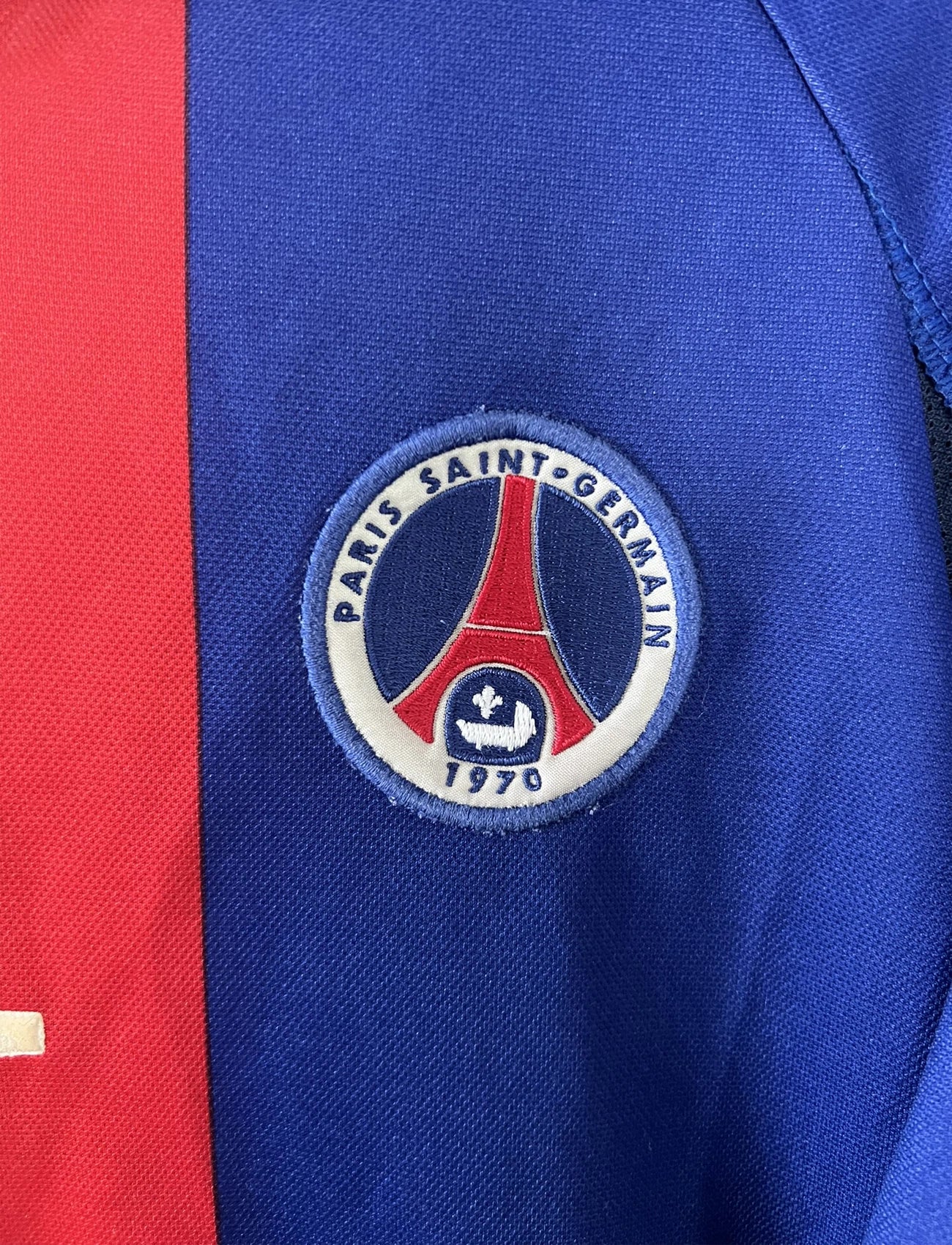 Maillot de foot vintage domicile du PSG de la saison 2000/2001. Le maillot est de couleur bleu et rouge. On peut retrouver l'équipementier nike et le sponsor OPEL