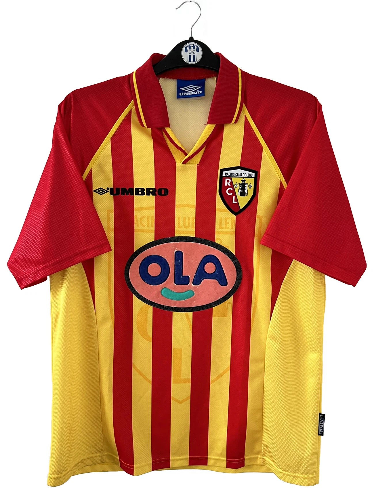 Maillot de foot vintage domicile rouge et jaune du RC Lens de la saison 1998/1999. On peut retrouver l'équipementier Umbro et le sponsor OLA. Il s'agit d'un maillot authentique d'époque.