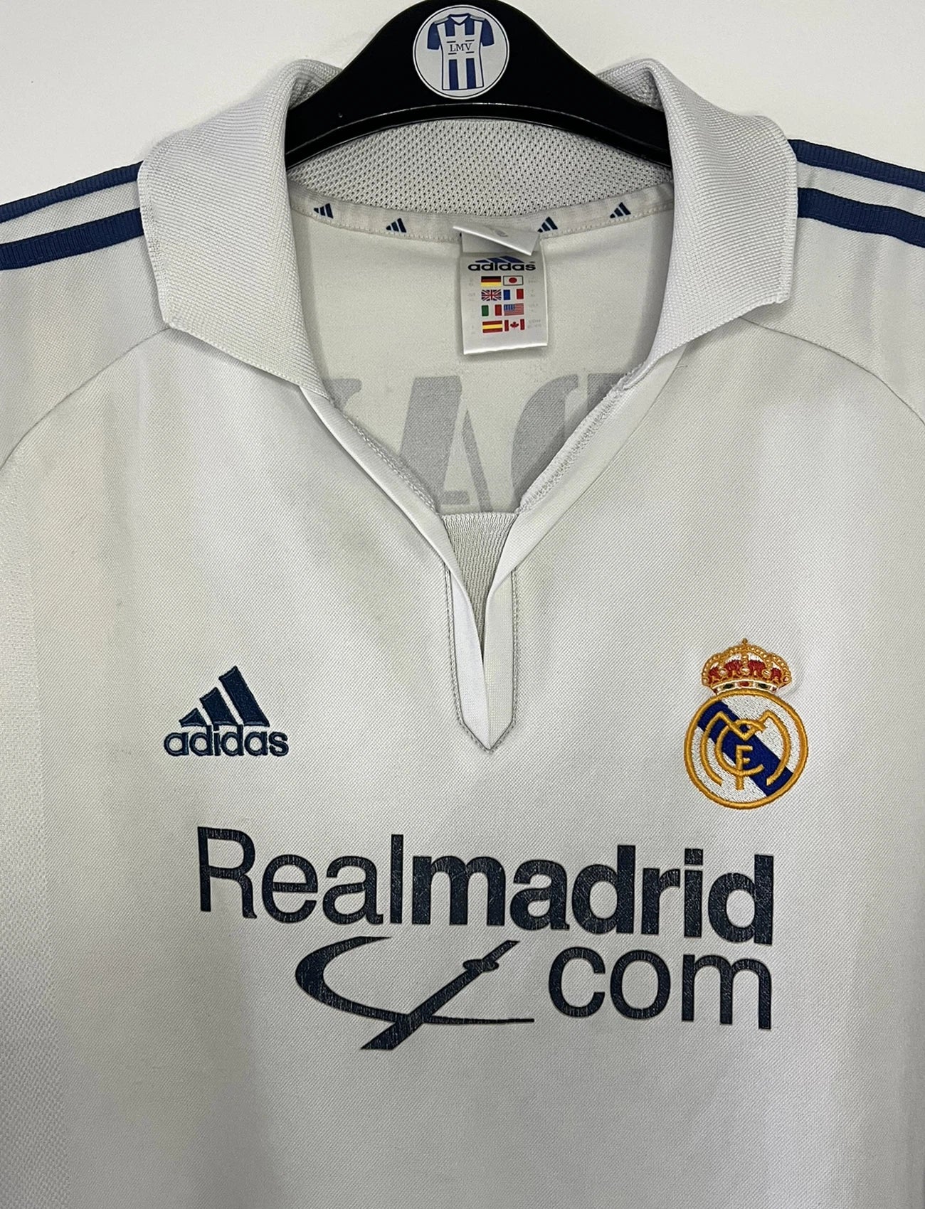 Maillot de foot vintage domicile du real madrid de la saison 2001-2002. Le maillot est de couleur blanc et noir. On peut retrouver l'équipementier adidas et le sponsor Real Madrid.com. Le maillot est floqué du numéro 5 Zinedine Zidane. Il s'agit d'un maillot authentique comportant les numéros 695856