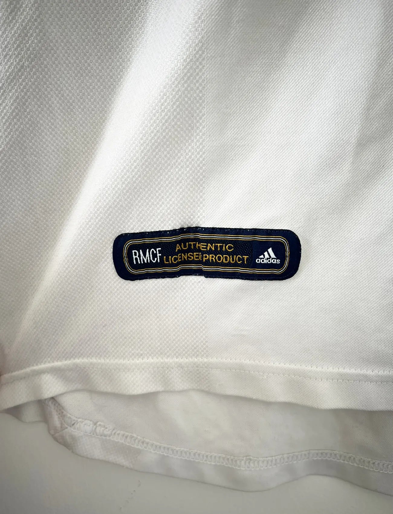 Maillot de foot vintage domicile du real madrid de la saison 2001-2002. Le maillot est de couleur blanc et noir. On peut retrouver l'équipementier adidas et le sponsor Real Madrid.com. Le maillot est floqué du numéro 5 Zinedine Zidane. Il s'agit d'un maillot authentique comportant les numéros 695856