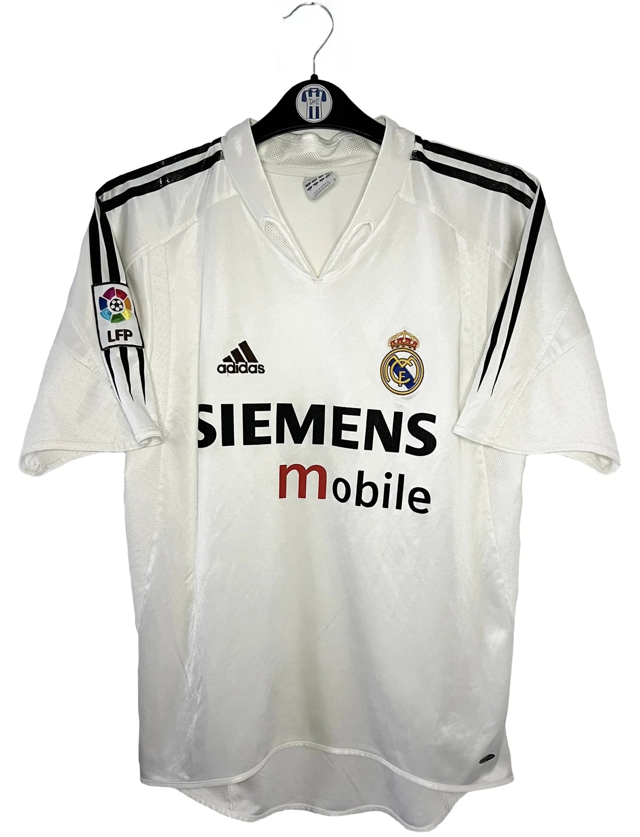 Maillot de foot vintage domicile blanc du real madrid de la saison 2004/2005. On peut retrouver l'équipementier Adidas et le sponsor Siemens. Il s'agit d'un maillot authentique d'époque comportant l'étiquette 367842