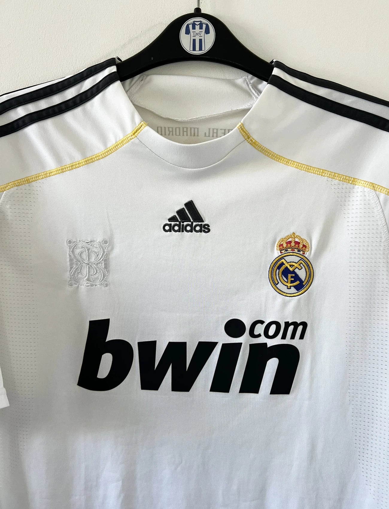 Maillot de foot vintage domicile du real madrid blanc de la saison 2009/2010. On peut retrouver l'équipementier adidas et le sponsor bwin. Le maillot est floqué du numéro 9 Cistiano Ronaldo. Il s'agit d'un maillot authentique comportant les numéros E84352