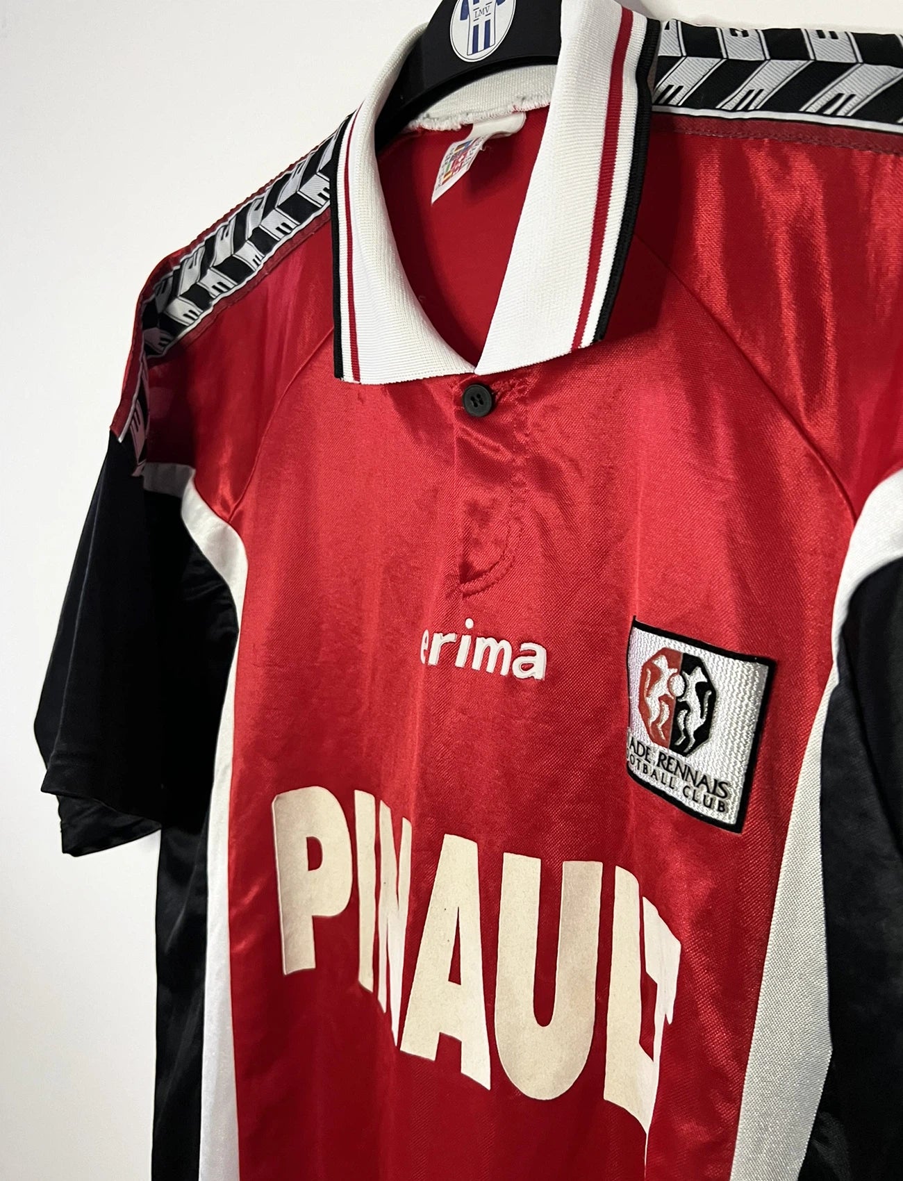 Maillot de foot vintage domicile rouge et noir du Stade Rennais de la saison 1997/1998. On peut retrouver l'équipementier Erima et le sponsor Pinault. Il s'agit d'un maillot authentique d'époque.