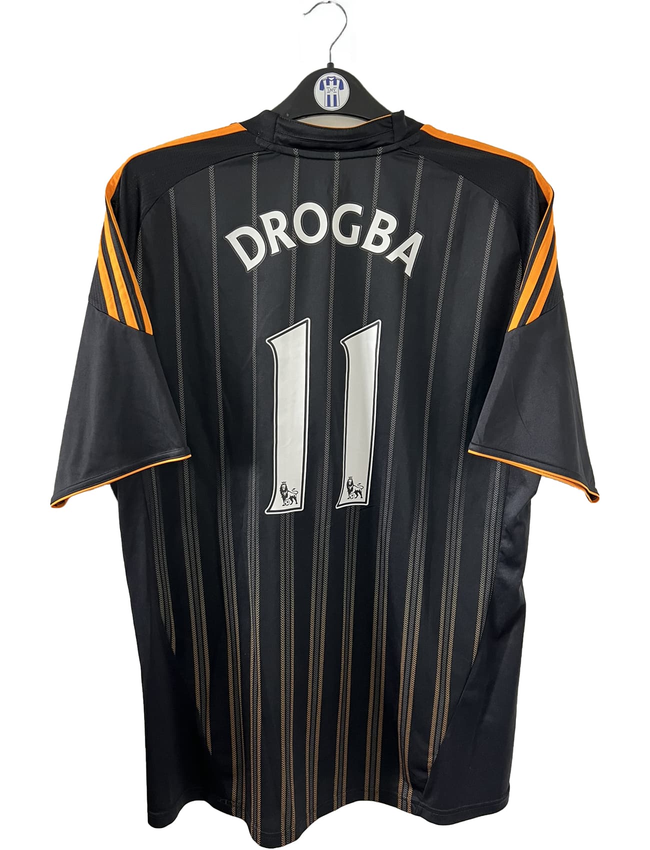 Maillot de foot vintage extérieur de chelsea de la saison 2010-2011. Le maillot est de couleur noir et orange. On peut retrouver l'équipementier adidas et le sponsor samsung. Le maillot est floqué du numéro 11 Didier Drogba. Il s'agit d'un maillot authentique comportant l'étiquette P00205