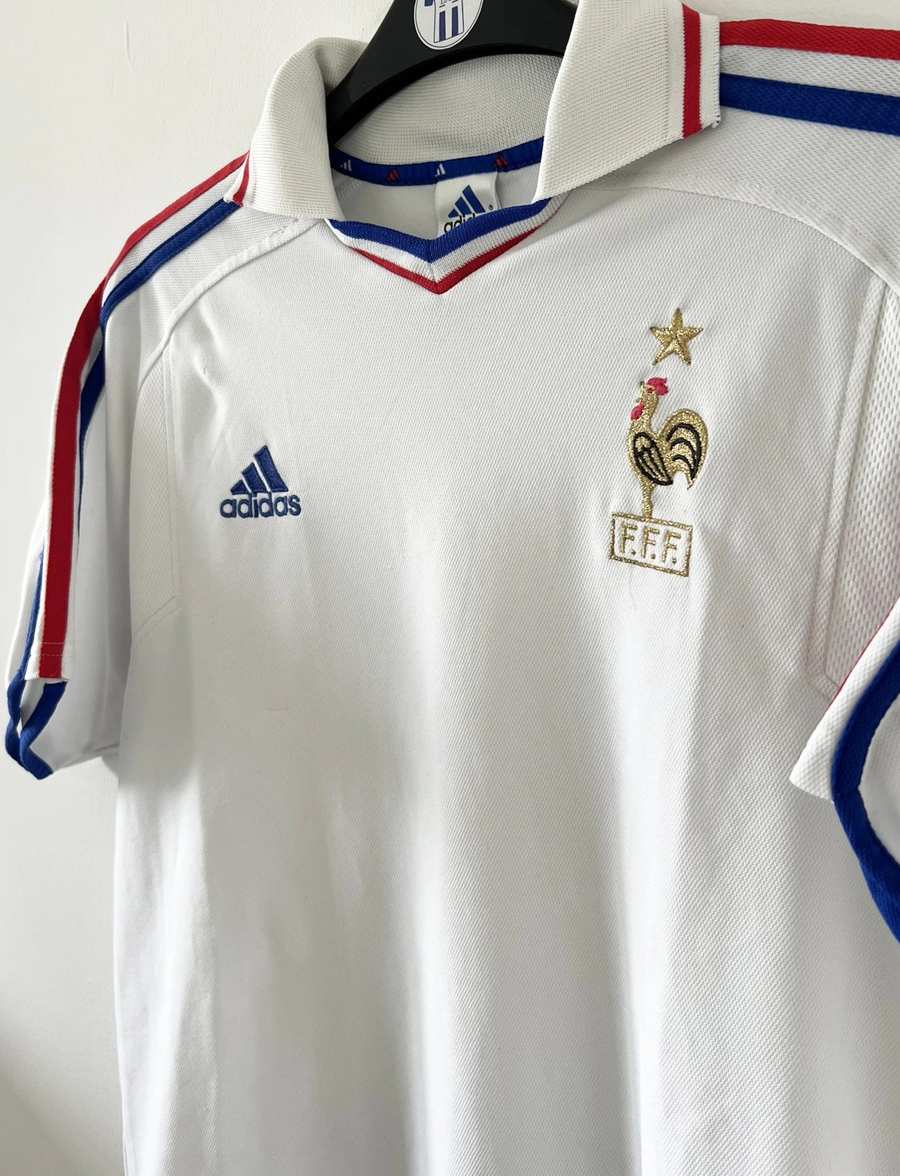 Maillot de foot vintage extérieur blanc de l'équipe de france 2000. On peut retrouver l'équipementier adidas. Il s'agit d'un maillot authentique d'époque comportant l'étiquette 647189.