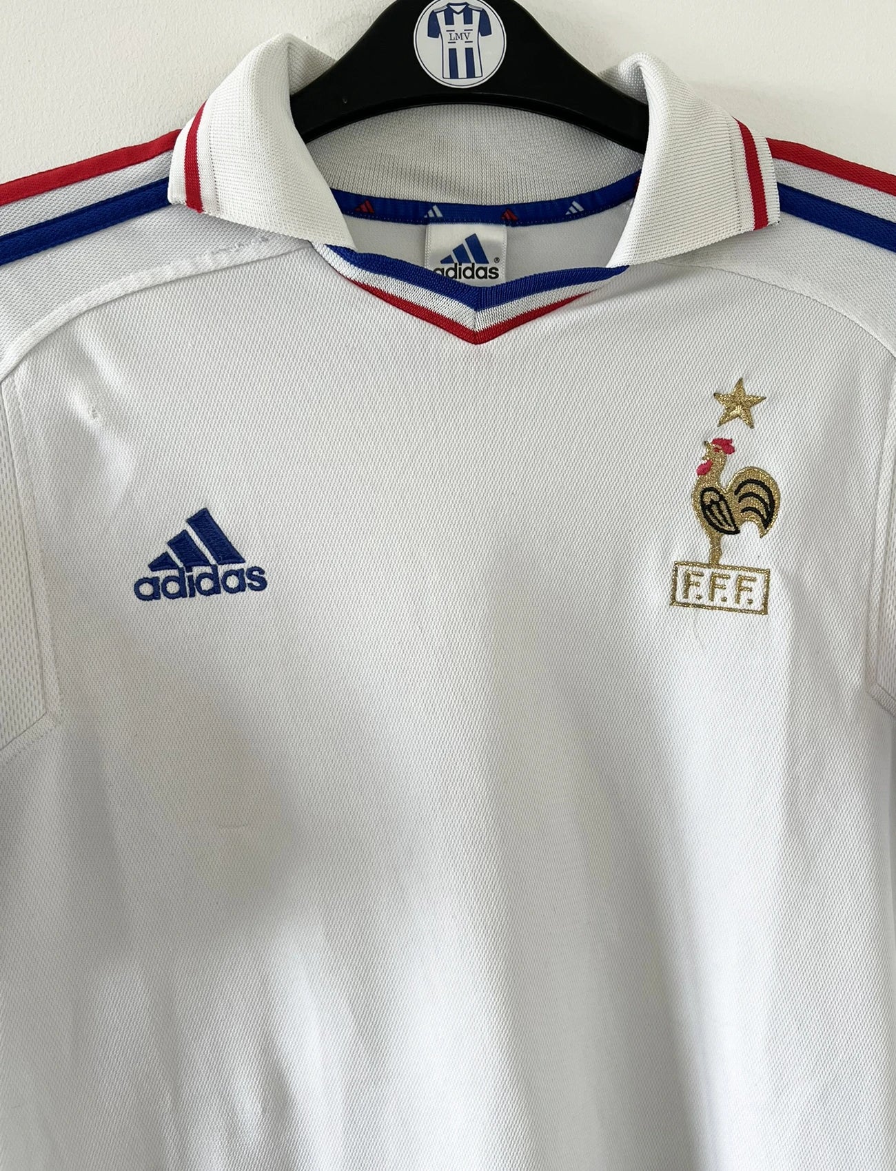 Maillot de foot vintage extérieur blanc de l'équipe de france 2000. On peut retrouver l'équipementier adidas. Il s'agit d'un maillot authentique d'époque comportant l'étiquette 647189.