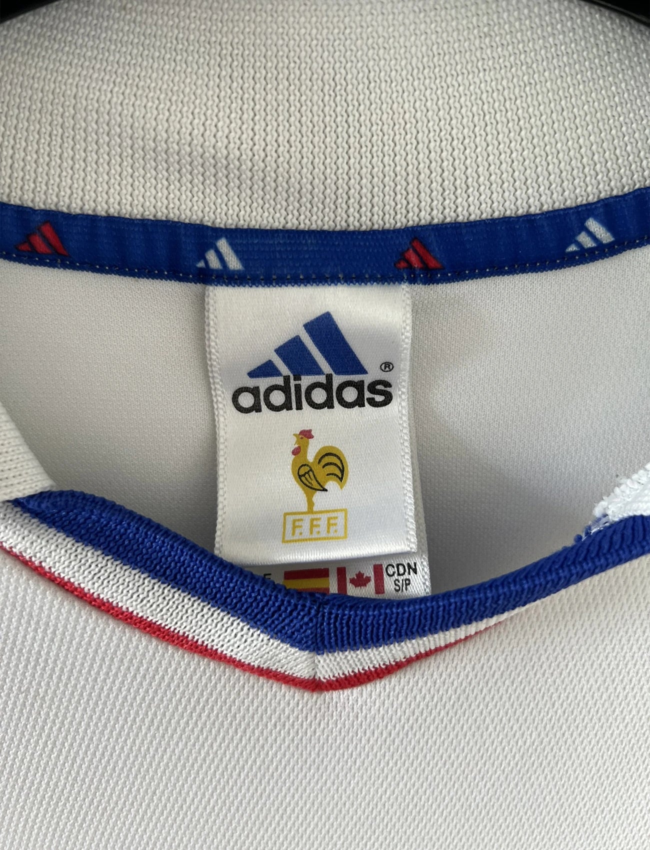 Maillot de foot vintage extérieur blanc de l'équipe de france 2000. On peut retrouver l'équipementier adidas. Il s'agit d'un maillot authentique d'époque comportant l'étiquette 647189.