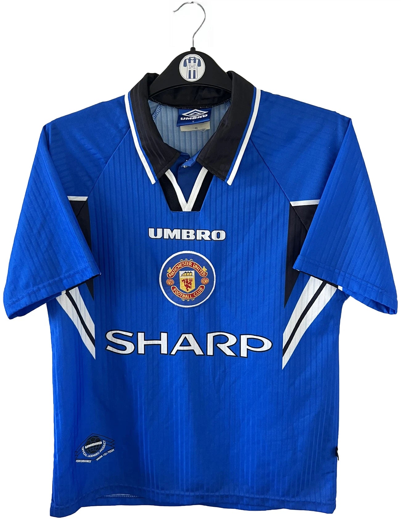 Maillot de foot vintage extérieur bleu de manchester united de la saison 1996-1998. On peut retrouver l'équipementier umbro et le sponsor sharp. Il s'agit d'un maillot autentique d'époque.