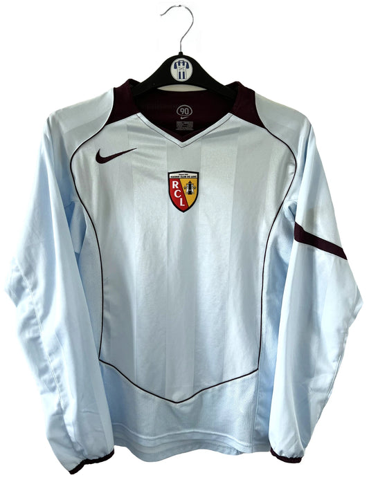 Maillot de foot vintage extérieur bleu et bordeaux du RC Lens de la saison 2004-2005. On peut retrouver l'équipementier Nike. Il s'agit d'un maillot authentique d'époque.