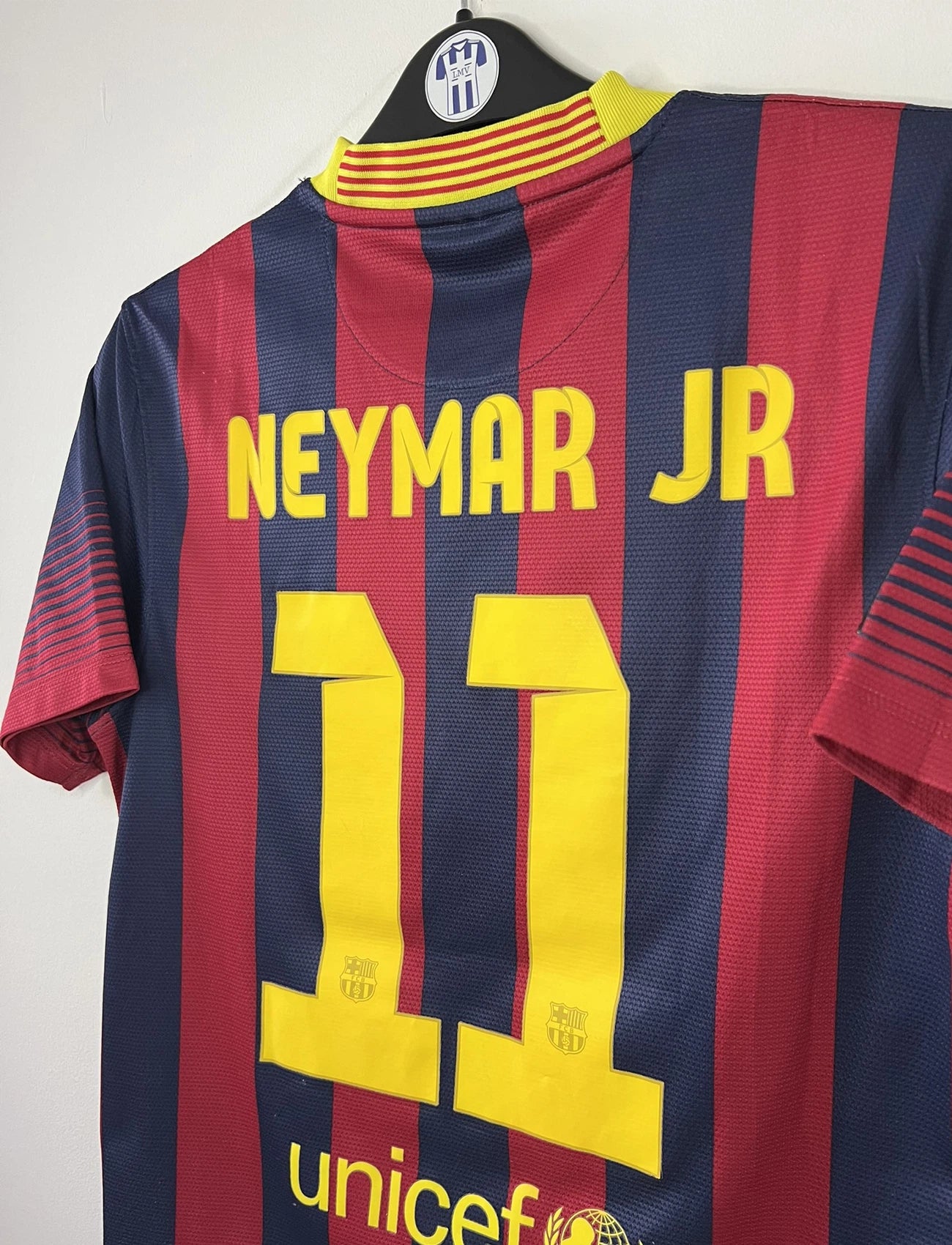 Maillot de foot vintage domicile du FC Barcelone de la saison 2013/14. Le maillot est de couleur rouge et bleu. On peut retrouver l'équipementier nike et le sponsor Qatar Airways. Le maillot est floqué du numéro 11 Neymar. Ils s'agit d'un maillot authentique comportant les numéros 532822-413