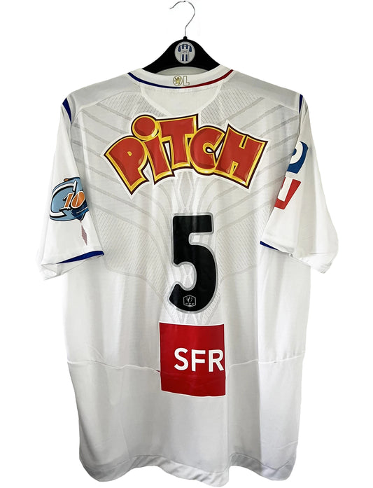 Maillot de foot vintage domicile blanc de l'OL de la saison 2007-2008. Il s'agit de l'édition coupe de france. On peut retrouver l'équipementier Umbro, ainsi que les sponsors SFR et Pitch. Le maillot est floqué du numéro 5 Mathieu Bodmer. Il s'agit d'un maillot authentique d'époque.