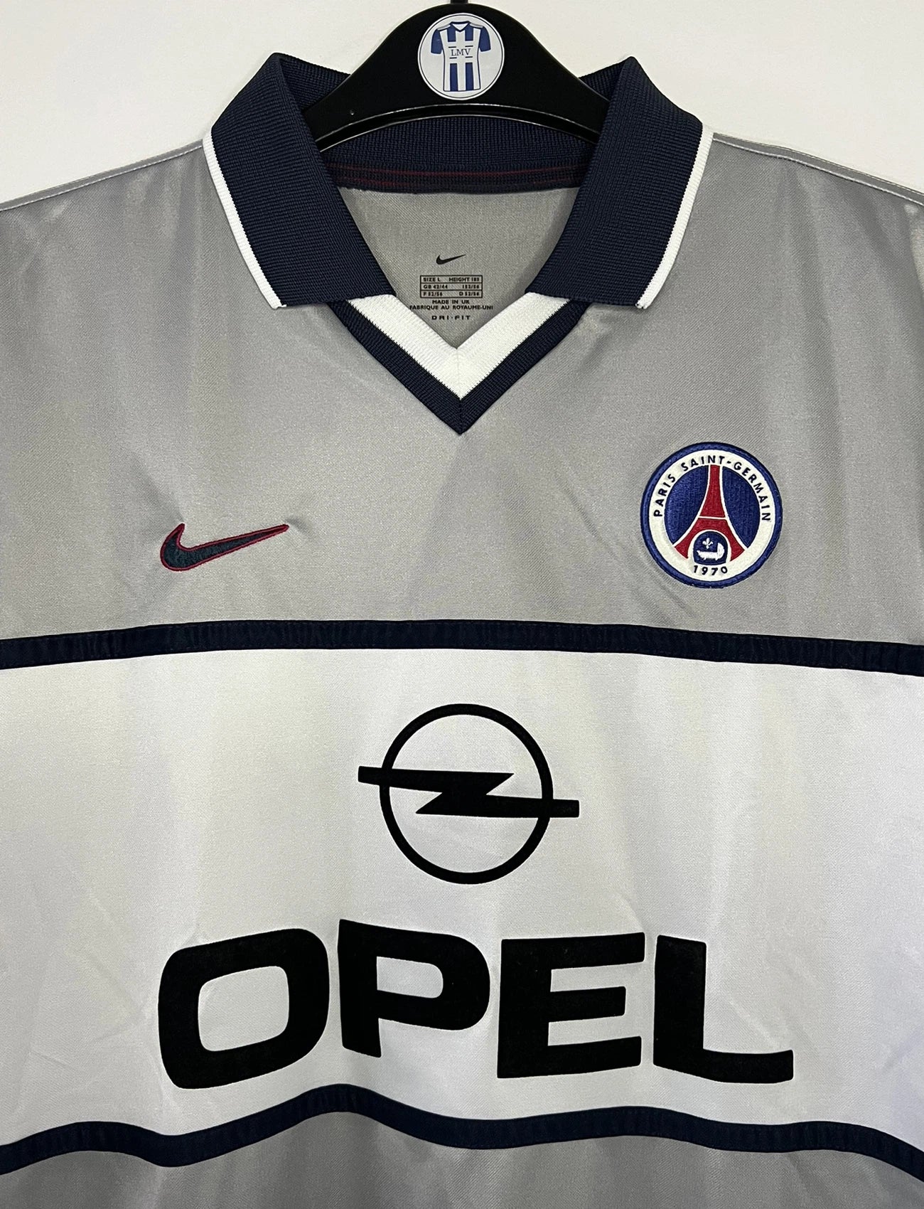 Maillot de foot vintage extérieur gris du PSG de la saison 2000-2001. On peut retrouver l'équipementier Nike et le sponsor Opel. Il s'agit d'un maillot authentique d'époque.