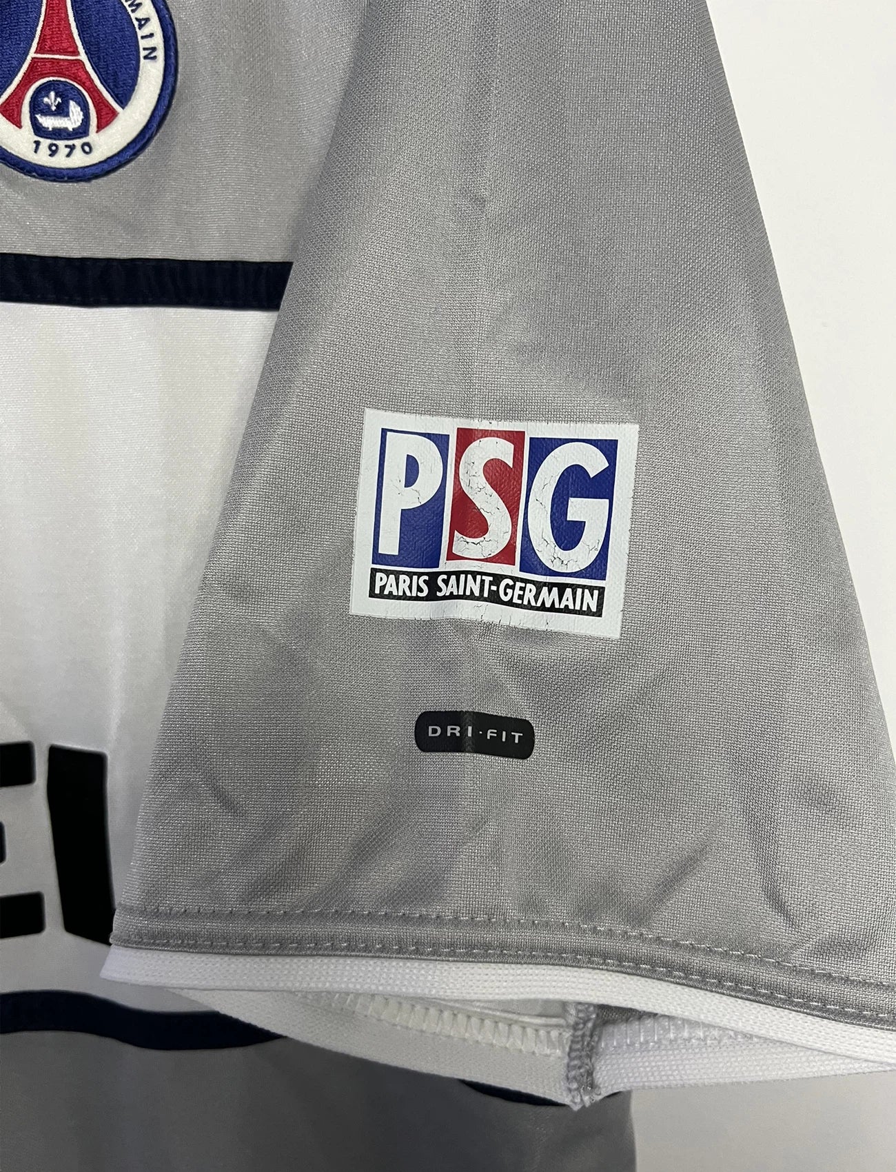 Maillot de foot vintage extérieur gris du PSG de la saison 2000-2001. On peut retrouver l'équipementier Nike et le sponsor Opel. Il s'agit d'un maillot authentique d'époque.