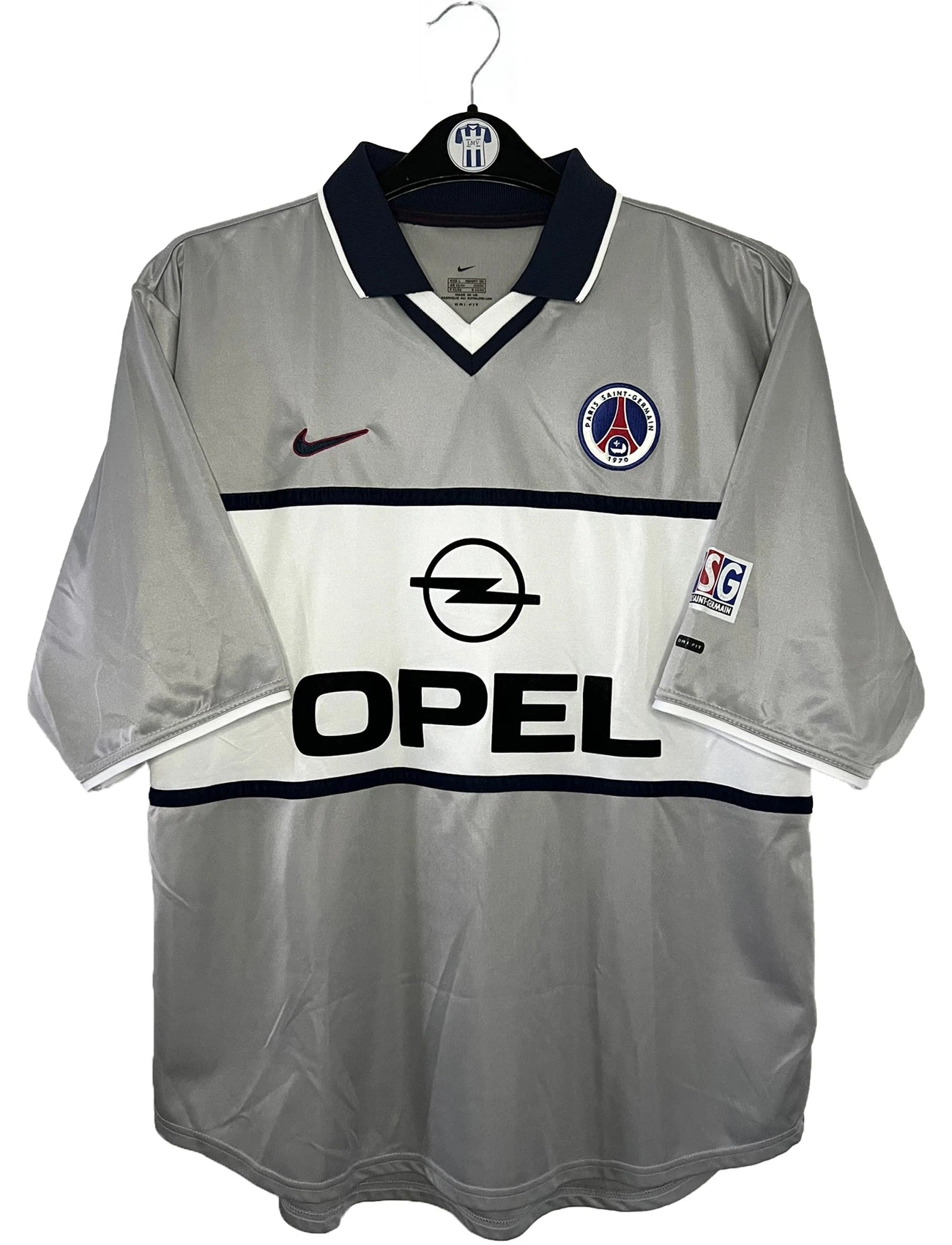 Maillot de foot vintage extérieur gris du PSG de la saison 2000-2001. On peut retrouver l'équipementier Nike et le sponsor Opel. Il s'agit d'un maillot authentique d'époque.