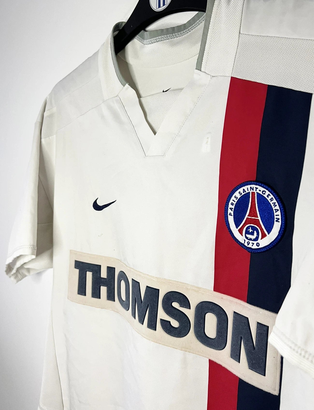 Maillot de foot vintage extérieur blanc du PSG de la saison 2002/2003. On peut retrouver l'équipementier Nike et le sponsor Thompson. Le maillot est floqué du numéro 2 Heinze. Il s'agit d'un maillot authentique d'époque comportant les numéros 184378.