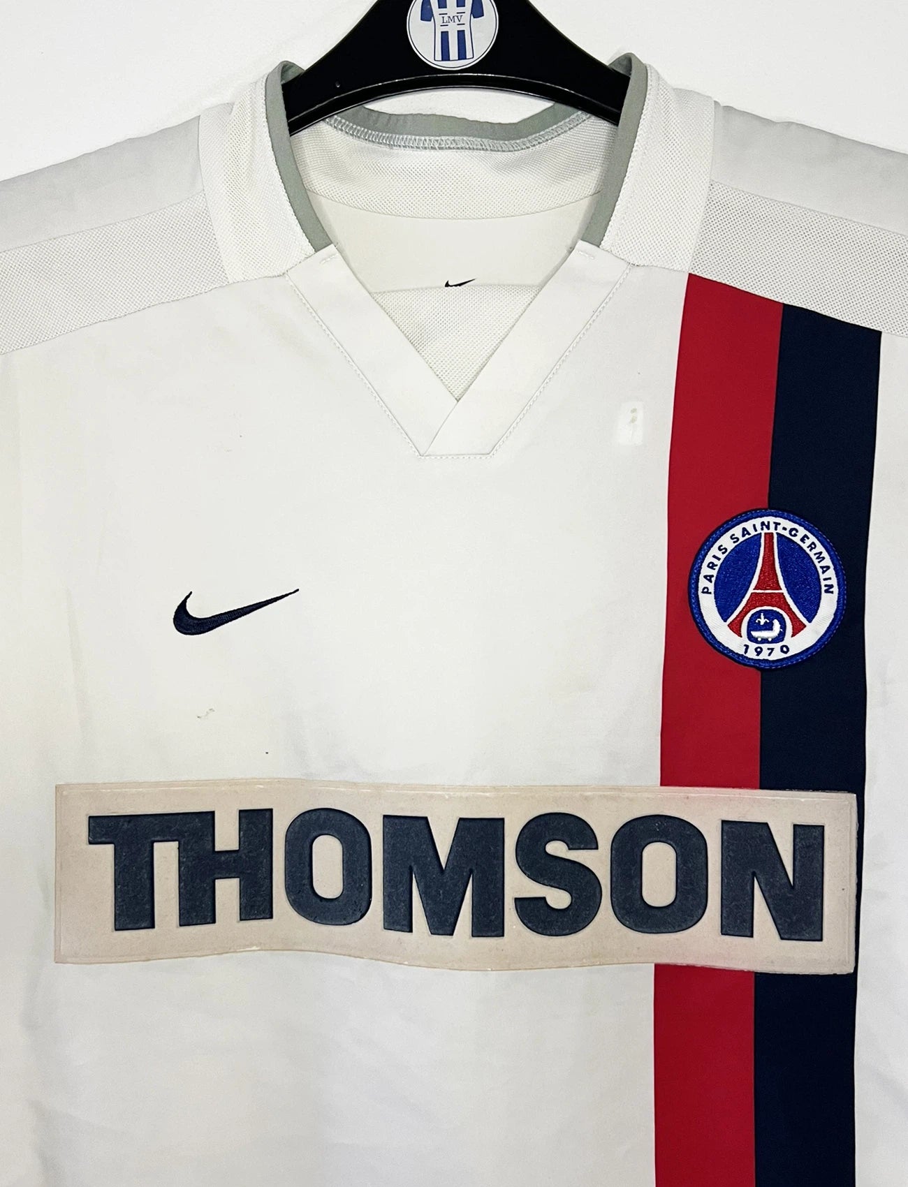 Maillot de foot vintage extérieur blanc du PSG de la saison 2002/2003. On peut retrouver l'équipementier Nike et le sponsor Thompson. Le maillot est floqué du numéro 2 Heinze. Il s'agit d'un maillot authentique d'époque comportant les numéros 184378.