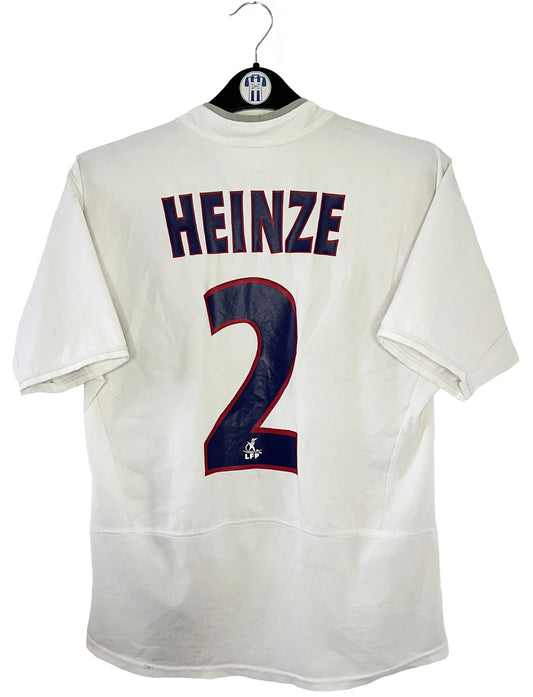 Maillot de foot vintage extérieur blanc du PSG de la saison 2002/2003. On peut retrouver l'équipementier Nike et le sponsor Thompson. Le maillot est floqué du numéro 2 Heinze. Il s'agit d'un maillot authentique d'époque comportant les numéros 184378.